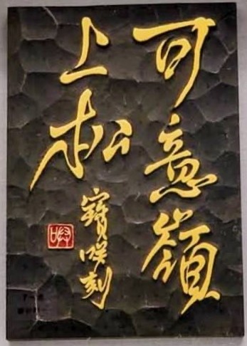 黒いソフトセラミックに金色で可意嶺上松と刻した佐能寶咲の刻字作品